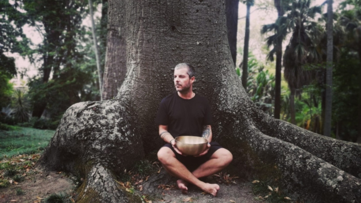 Gonçalo sitting with a tibetan bowl in front of a tree